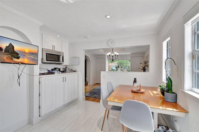 322 Cornell Dr, Lake Worth, FL 33460 - dining area with a chandelier, crown molding, arched walkways, recessed lighting, and light tile patterned floors