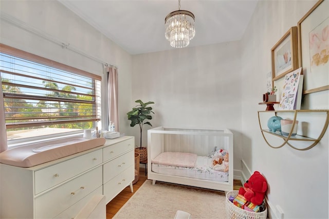 322 Cornell Dr, Lake Worth, FL 33460 - bedroom with wood finished floors, a chandelier, and a crib