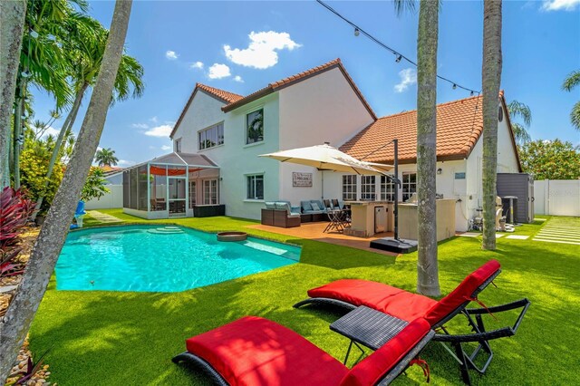 19367 NW 13th St, Pembroke Pines, FL 33029 - rear view of property featuring a sunroom, a tiled roof, stucco siding, a yard, and an outdoor hangout area