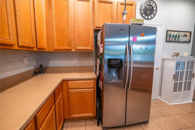 1780 Nature Cove Ln, Clermont, FL 34711 - kitchen featuring stainless steel fridge with ice dispenser, light tile patterned floors, light countertops, and brown cabinetry