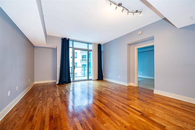 260 S Osceola Ave Unit 710, Orlando, FL 32801 - empty room with expansive windows, wood finished floors, rail lighting, and a smoke detector