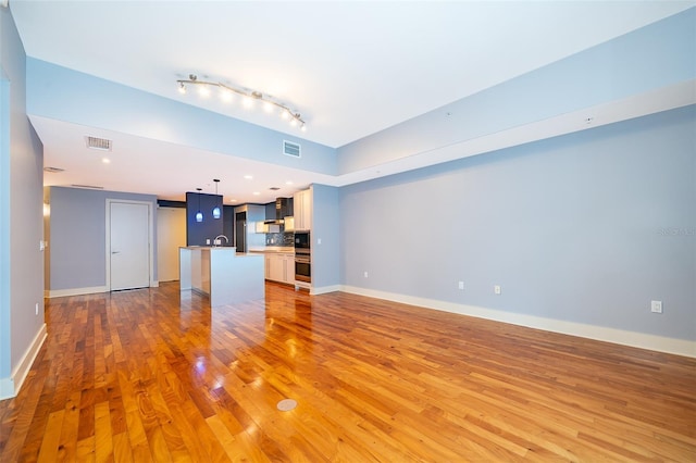 260 S Osceola Ave Unit 710, Orlando, FL 32801 - unfurnished living room featuring light wood finished floors and track lighting