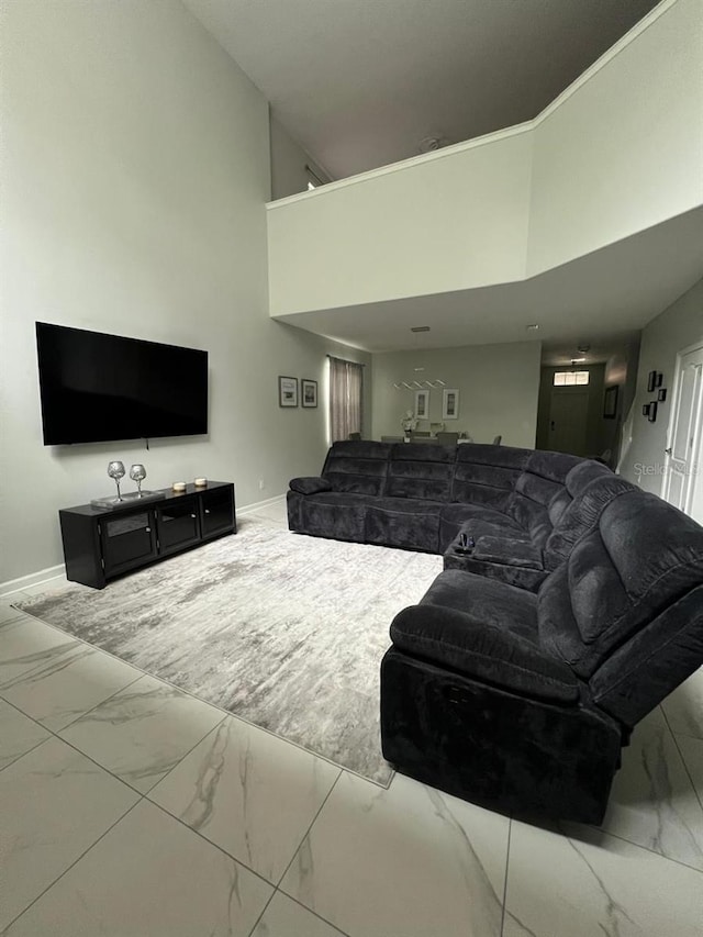 8894 Candy Palm Rd, Kissimmee, FL 34747 - living area featuring marble finish flooring, a towering ceiling, and baseboards