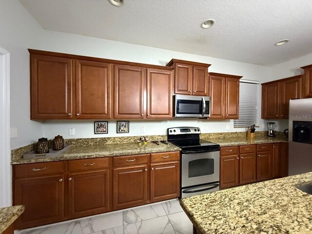 8894 Candy Palm Rd, Kissimmee, FL 34747 - kitchen featuring appliances with stainless steel finishes, light marble finish floors, light stone counters, a textured ceiling, and recessed lighting