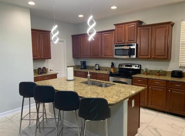 8894 Candy Palm Rd, Kissimmee, FL 34747 - kitchen featuring stainless steel appliances, light marble finish floors, a breakfast bar area, a kitchen island with sink, and recessed lighting