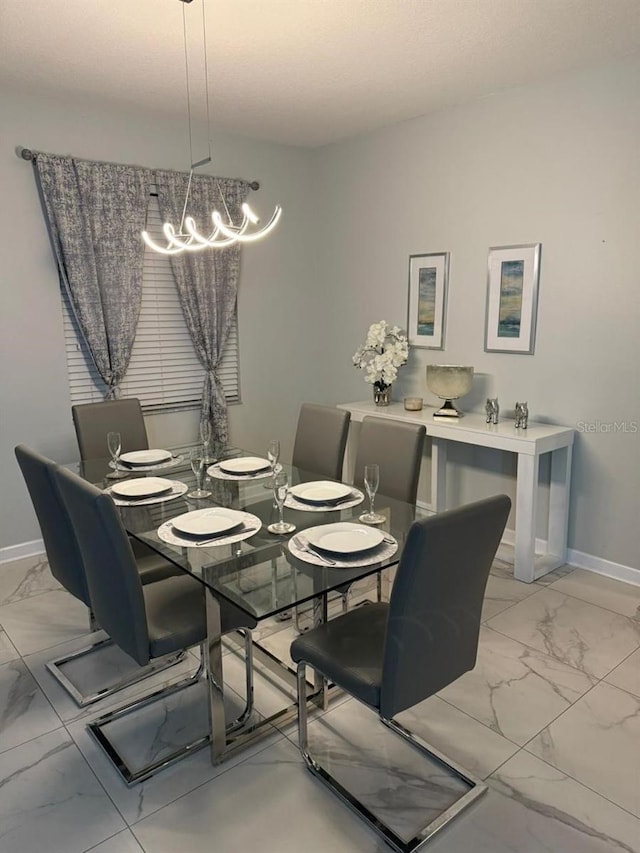 8894 Candy Palm Rd, Kissimmee, FL 34747 - dining space featuring light marble finish flooring, a chandelier, and baseboards