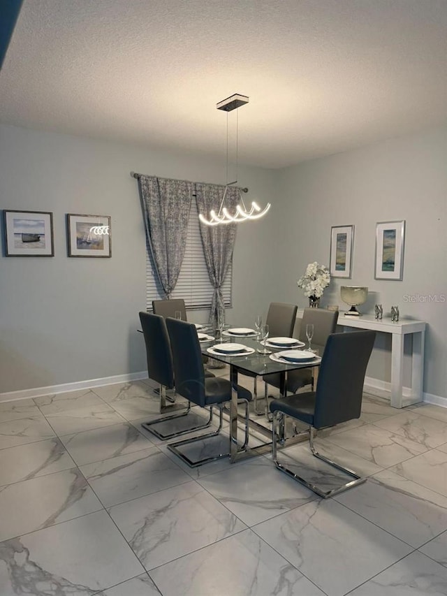 8894 Candy Palm Rd, Kissimmee, FL 34747 - dining room with light marble finish floors, a chandelier, baseboards, and a textured ceiling