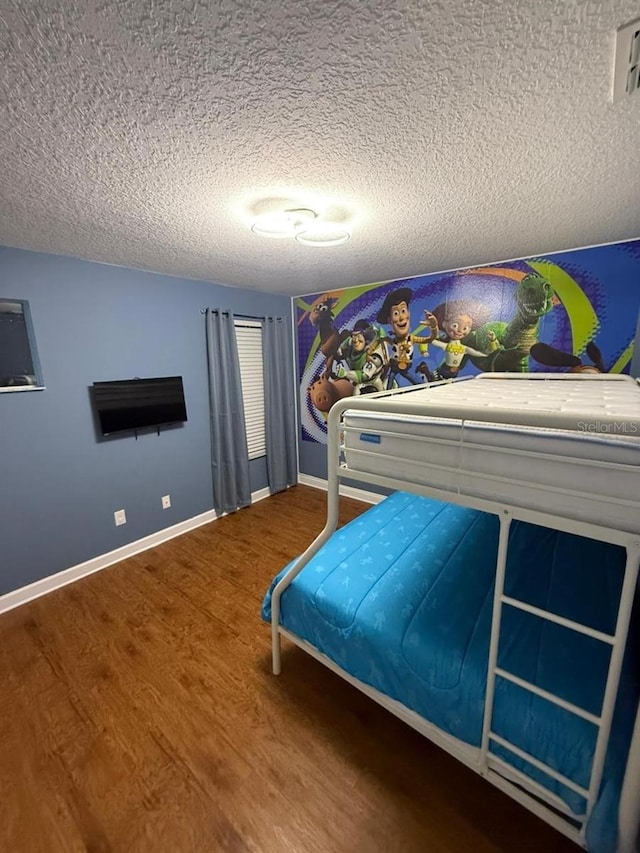 8894 Candy Palm Rd, Kissimmee, FL 34747 - bedroom with a textured ceiling, wood finished floors, and baseboards