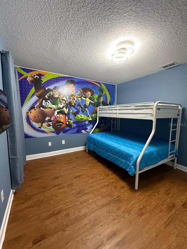 8894 Candy Palm Rd, Kissimmee, FL 34747 - bedroom with a textured ceiling, wood finished floors, and baseboards