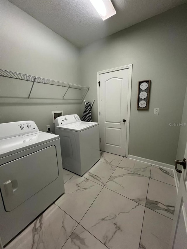 8894 Candy Palm Rd, Kissimmee, FL 34747 - laundry room with washer and clothes dryer, light marble finish flooring, a textured ceiling, and baseboards