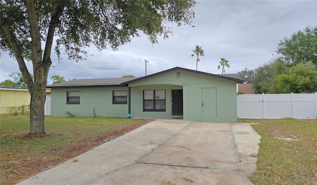 single story home with concrete block siding, concrete driveway, and a shingled roof