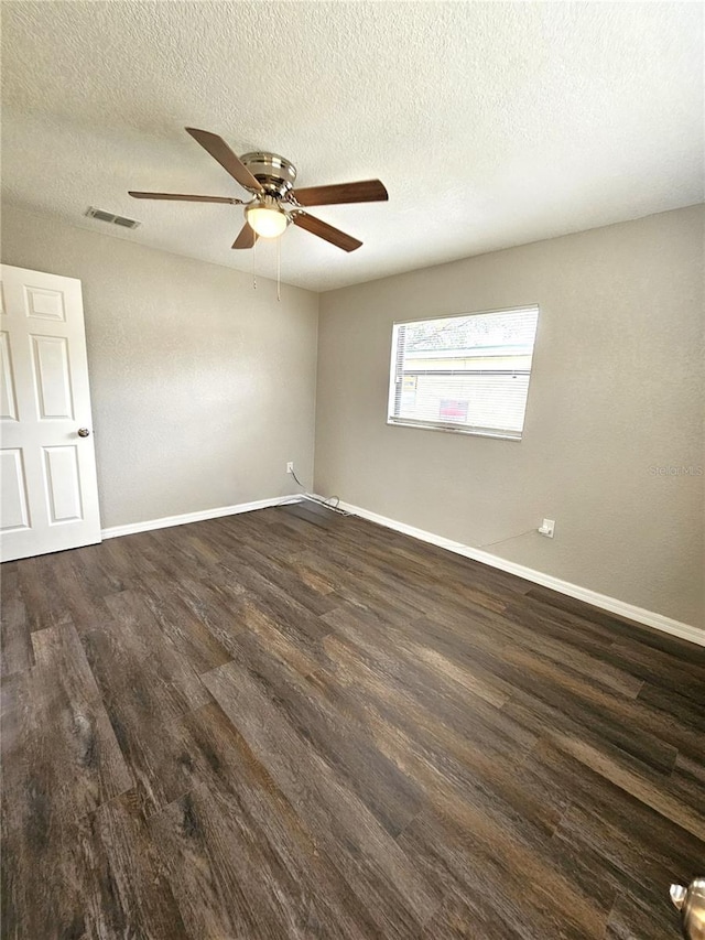 unfurnished room with wood finished floors, ceiling fan, baseboards, and a textured ceiling