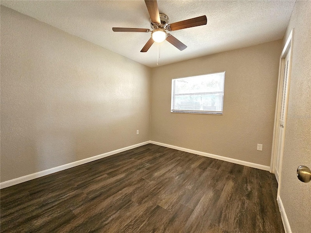 empty room featuring dark wood-style floors, ceiling fan, a textured wall, and a textured ceiling