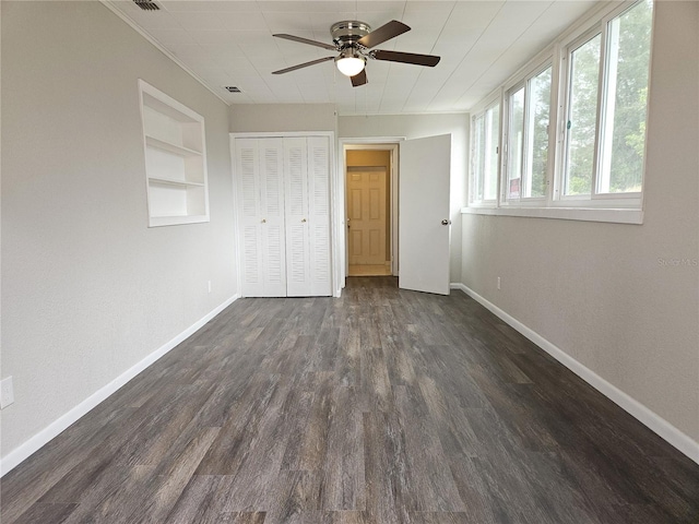 unfurnished bedroom with dark wood-type flooring, a closet, and ceiling fan