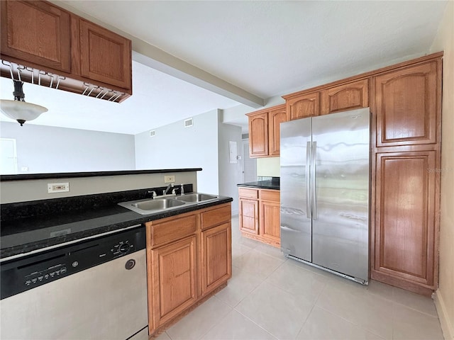 250 N Banana River Dr Unit H11, Merritt Island, FL 32952 - kitchen with appliances with stainless steel finishes, a sink, dark countertops, light tile patterned floors, and brown cabinets