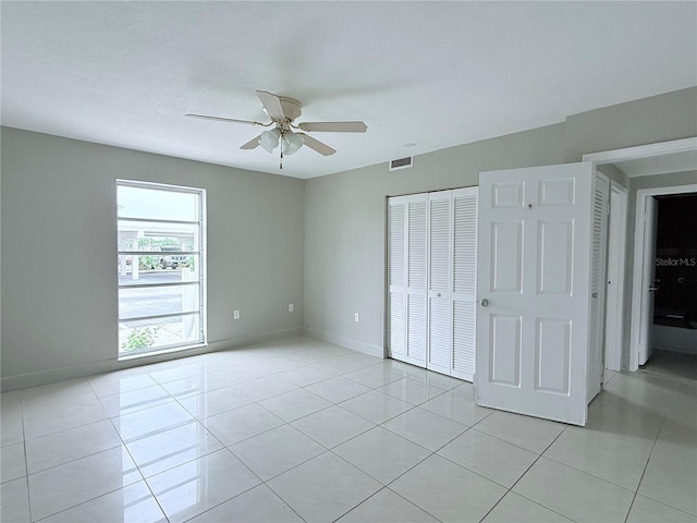 250 N Banana River Dr Unit H11, Merritt Island, FL 32952 - unfurnished bedroom featuring light tile patterned floors, a closet, baseboards, and a ceiling fan
