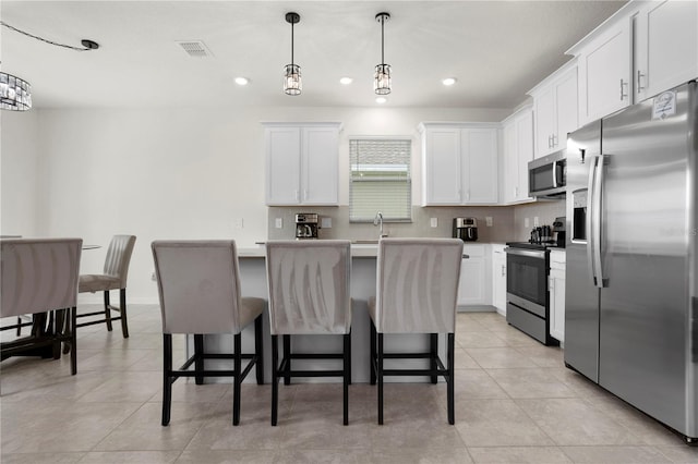 884 Laurel View Way, Groveland, FL 34736 - kitchen featuring stainless steel appliances, a sink, a center island, white cabinetry, and a kitchen breakfast bar