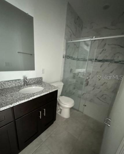 104 W Gondolier Pl, Citrus Springs, FL 34434 - bathroom with vanity, a marble finish shower, and tile patterned flooring