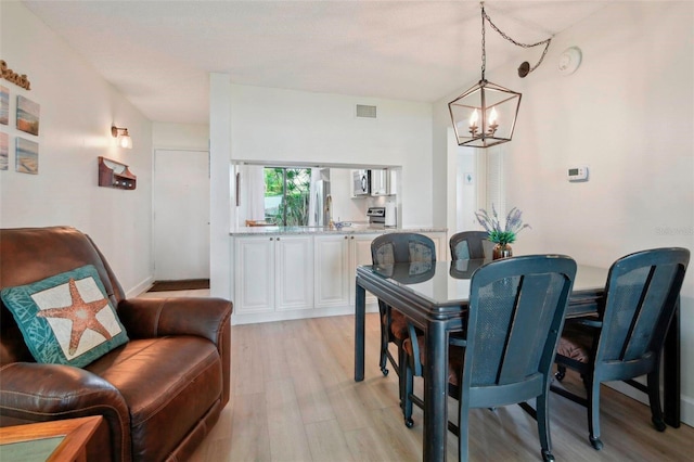 6218 Palma Del Mar Blvd S Unit 103, Saint Petersburg, FL 33715 - dining space with a chandelier and light wood-style flooring