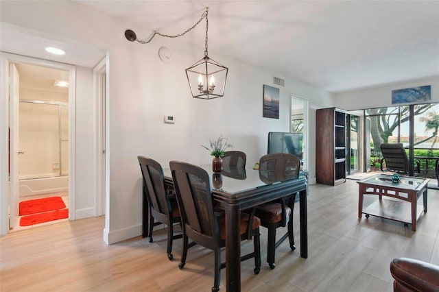 6218 Palma Del Mar Blvd S Unit 103, Saint Petersburg, FL 33715 - dining area featuring a chandelier, light wood-style floors, and baseboards