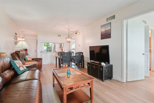 6218 Palma Del Mar Blvd S Unit 103, Saint Petersburg, FL 33715 - living room with light wood-type flooring and a chandelier