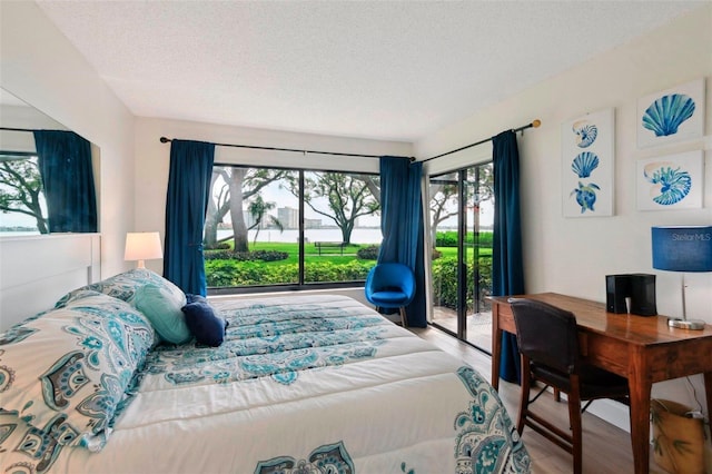 6218 Palma Del Mar Blvd S Unit 103, Saint Petersburg, FL 33715 - bedroom with multiple windows, access to exterior, a textured ceiling, and wood finished floors