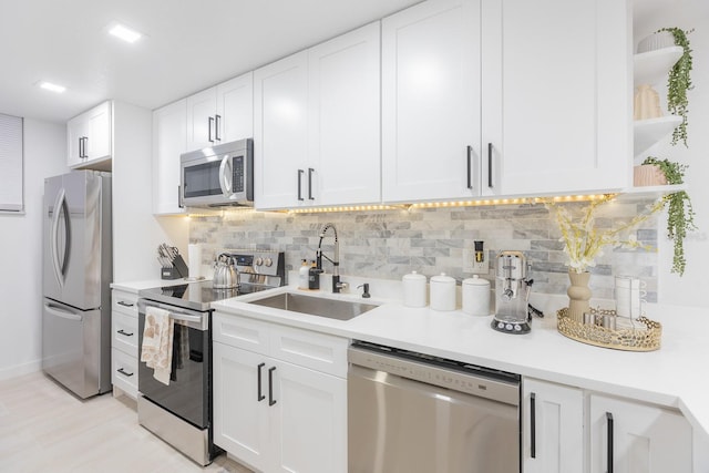 701 S Atlantic Ave Unit Ut21, New Smyrna Beach, FL 32169 - kitchen featuring appliances with stainless steel finishes, a sink, backsplash, light countertops, and white cabinetry