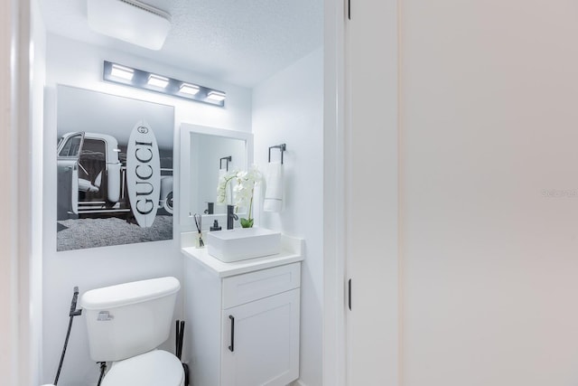 701 S Atlantic Ave Unit Ut21, New Smyrna Beach, FL 32169 - half bathroom with vanity, toilet, and a textured ceiling