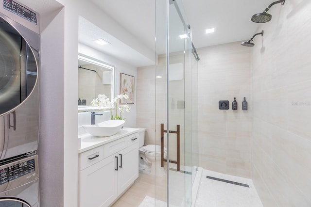701 S Atlantic Ave Unit Ut21, New Smyrna Beach, FL 32169 - full bathroom with stacked washer / drying machine, a stall shower, vanity, and toilet