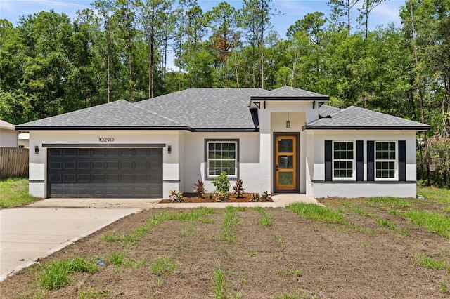 10290 N Biscayne Dr, Citrus Springs, FL 34434 - prairie-style home featuring roof with shingles, an attached garage, driveway, and stucco siding