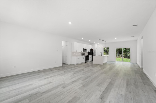10290 N Biscayne Dr, Citrus Springs, FL 34434 - unfurnished living room featuring recessed lighting and light wood-style floors