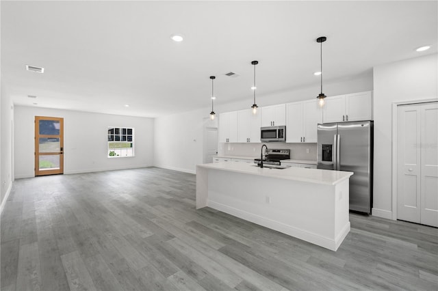 10290 N Biscayne Dr, Citrus Springs, FL 34434 - kitchen with appliances with stainless steel finishes, a center island with sink, white cabinetry, light countertops, and recessed lighting