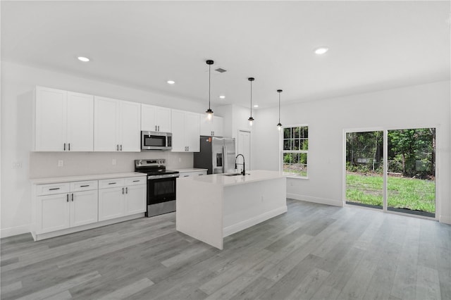 10290 N Biscayne Dr, Citrus Springs, FL 34434 - kitchen with stainless steel appliances, light wood-style flooring, a kitchen island with sink, light countertops, and recessed lighting