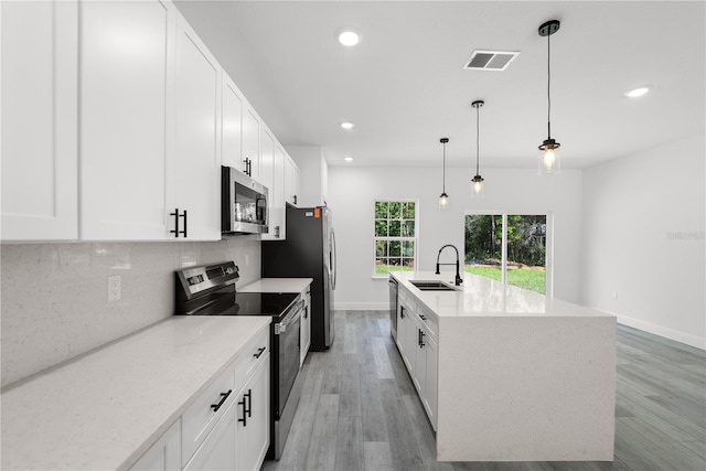 10290 N Biscayne Dr, Citrus Springs, FL 34434 - kitchen featuring appliances with stainless steel finishes, recessed lighting, backsplash, light wood finished floors, and white cabinetry