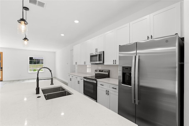 10290 N Biscayne Dr, Citrus Springs, FL 34434 - kitchen with appliances with stainless steel finishes, white cabinetry, decorative light fixtures, light stone countertops, and recessed lighting