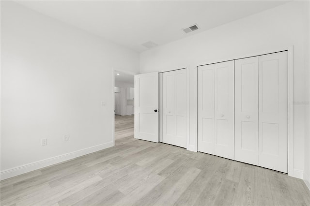 10290 N Biscayne Dr, Citrus Springs, FL 34434 - unfurnished bedroom featuring light wood-type flooring and two closets