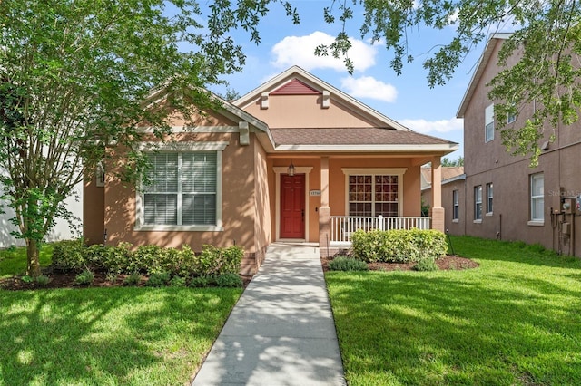 13768 Bluebird Pond Rd, Windermere, FL 34786 - bungalow with covered porch, a front lawn, stucco siding, and a shingled roof
