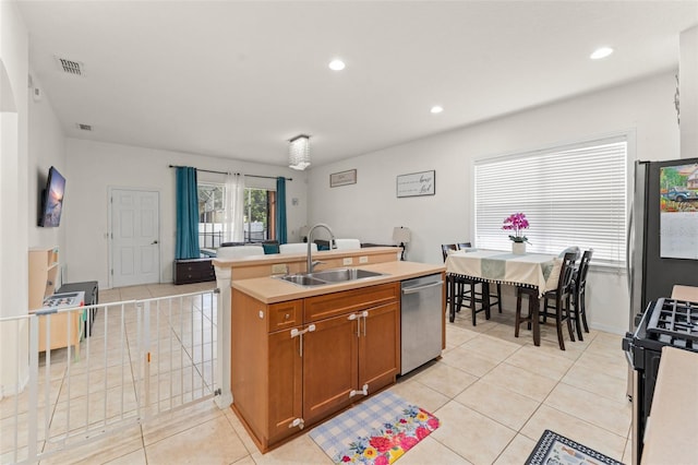 13768 Bluebird Pond Rd, Windermere, FL 34786 - kitchen featuring stainless steel appliances, a sink, light tile patterned flooring, brown cabinetry, and recessed lighting