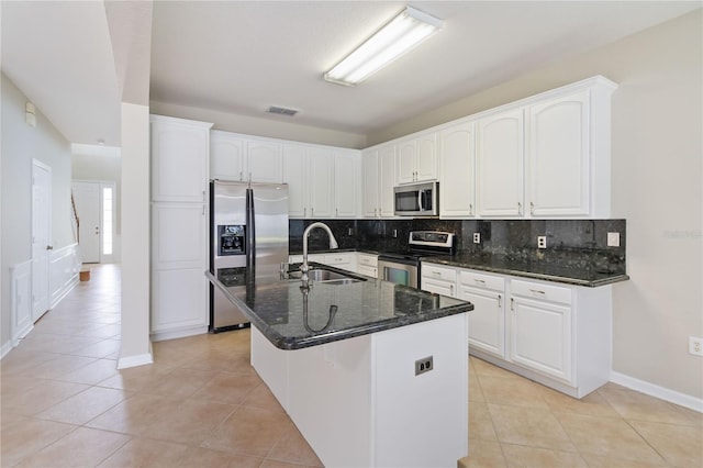 13519 Bicton Ln, Windermere, FL 34786 - kitchen with stainless steel appliances, tasteful backsplash, white cabinetry, light tile patterned floors, and dark stone counters