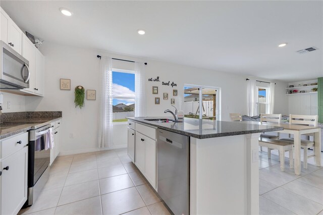 1854 Juneberry St, Clermont, FL 34715 - kitchen with appliances with stainless steel finishes, plenty of natural light, a center island with sink, dark stone counters, and recessed lighting