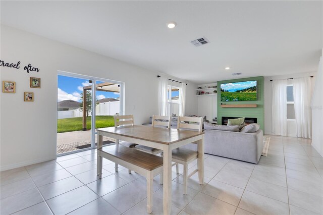1854 Juneberry St, Clermont, FL 34715 - dining area with a lit fireplace, light tile patterned floors, and recessed lighting