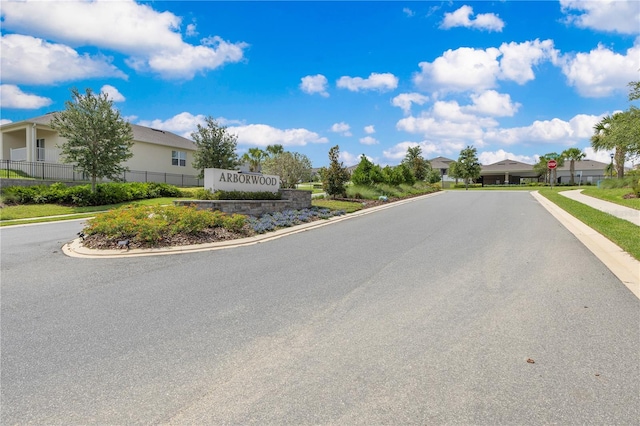 1854 Juneberry St, Clermont, FL 34715 - view of asphalt road with curbs, sidewalks, traffic signs, and a residential view