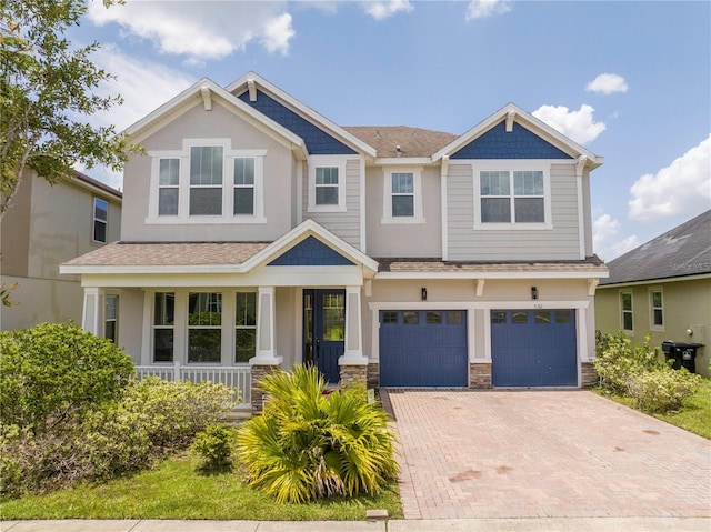 5161 Dove Tree St, Orlando, FL 32811 - craftsman-style house featuring a porch, decorative driveway, an attached garage, and a shingled roof