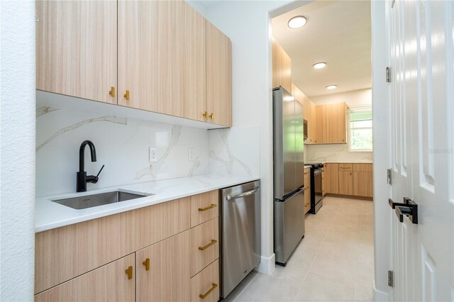 5161 Dove Tree St, Orlando, FL 32811 - kitchen featuring light brown cabinetry, appliances with stainless steel finishes, backsplash, light tile patterned floors, and recessed lighting
