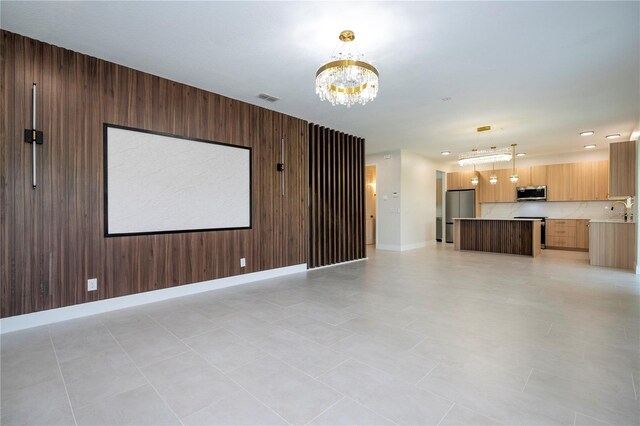 5161 Dove Tree St, Orlando, FL 32811 - unfurnished living room featuring a chandelier, wooden walls, and recessed lighting