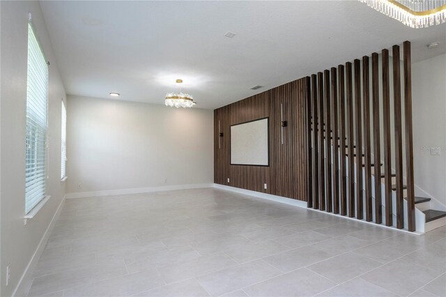 5161 Dove Tree St, Orlando, FL 32811 - unfurnished room with a chandelier, healthy amount of natural light, and wood walls