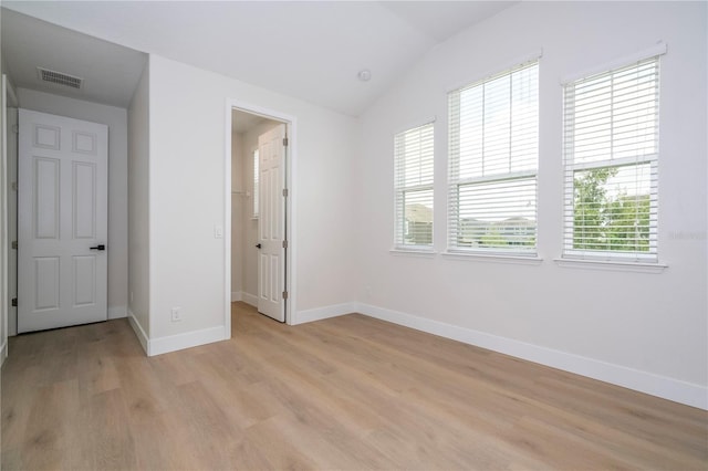5161 Dove Tree St, Orlando, FL 32811 - unfurnished bedroom with multiple windows, light wood finished floors, vaulted ceiling, and a spacious closet