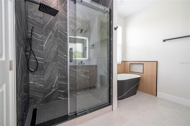 5161 Dove Tree St, Orlando, FL 32811 - bathroom featuring a marble finish shower, a freestanding bath, tile patterned floors, and a wainscoted wall