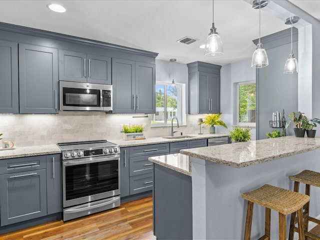 2244 Brookshire Ave, Winter Park, FL 32792 - kitchen featuring appliances with stainless steel finishes, a breakfast bar area, decorative backsplash, light stone counters, and healthy amount of natural light