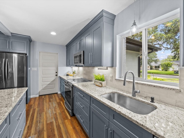 2244 Brookshire Ave, Winter Park, FL 32792 - kitchen with appliances with stainless steel finishes, decorative backsplash, light stone counters, dark wood-style floors, and pendant lighting